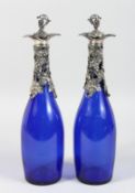 A PAIR OF BRISTOL BLUE DECANTER BOTTLES with plated fruiting vines.