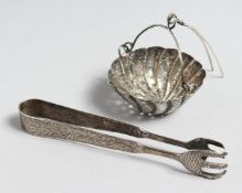 A PAIR OF SILVER SUGAR TONGS AND A TEA STRAINER (2)