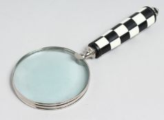 A MAGNIFYING GLASS with chequered handle.