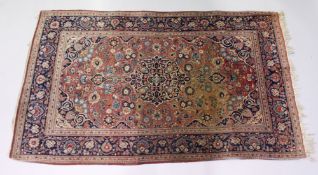 AN EARLY 20TH CENTURY PERSIAN RUG, rust ground with all over floral decoration. 7ft 2ins x 4ft