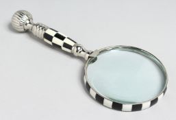 A MAGNIFYING GLASS with chequered handle.