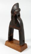 A CARVED WOOD TRIBAL BIRD'S HEAD PULLEY. 7.5ins high.