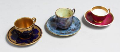 A WEDGWOOD LUSTRE MINIATURE CUP AND SAUCER WITH GILT DECORATION, A COALPORT BLUE AND RAISED GILT CUP