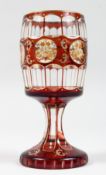 A GOOD BOHEMIAN GOBLET with a ruby overlay and six etched circles of flowers. 6.5ins high.