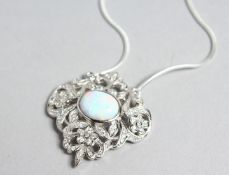 A SILVER AND OPAL PENDANT on a chain.