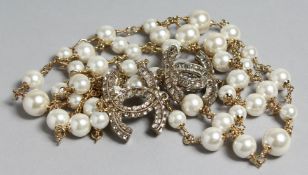 A GOOD CHANEL LONG LARGE PEARL NECKLACE with two entwined brilliant 'C's'.