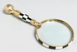A MAGNIFYING GLASS with chequered handle.