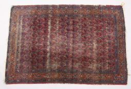 AN EARLY 20TH CENTURY PERSIAN RUG, red ground with all overt design of stylized Botek. 6ft 10ins x