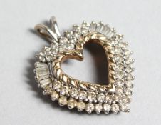 A 9CT GOLD BAGUETTE AND ROUND DIAMOND HEART SHAPED PENDANT.