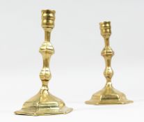 A PAIR OF GEORGIAN BRASS CANDLESTICKS. 7ins high.