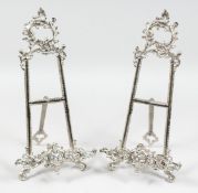 A PAIR OF SILVERED EASELS.