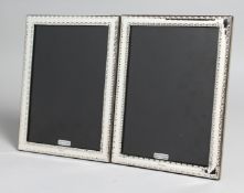 A PAIR OF SILVER AND ENAMEL PHOTOGRAPH FRAMES. 8ins x 6ins.