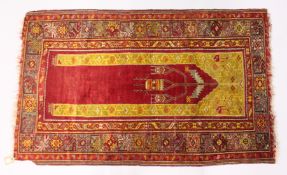 AN EARLY 20TH CENTURY ANATOLIAN PRAYER RUG, red ground with geometric design. 5ft 6ins x 3ft 4ins.