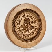 A LARGE CIRCULAR WOODEN BUTTER MOULD, 
