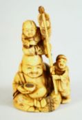 A JAPANESE CARVED IVORY NETSUKE, depicting buddha with children, signed to base, 6cm high.