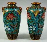 A PAIR OF CHINESE CLOISONNE TWIN HANDLE VASES, the body of each decorated with flora and