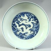 A CHINESE BLUE AND WHITE PORCELAIN DISH, decorated with a white dragon to the centre, the exterior