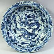 A LARGE CHINESE BLUE AND WHITE PORCELAIN DRAGON DISH, the centre painted with a large dragon