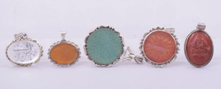FOUR GOOD ISLAMIC CARVED CALLIGRAPHIC SEALS of various stones in white metal frames, together with a