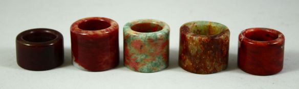 FIVE CHINESE HARDSTONE ARCHER'S RINGS.
