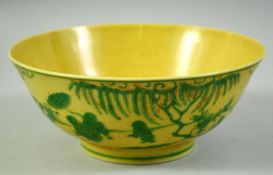 A CHINESE YELLOW GROUND AND GREEN PORCELAIN BOWL, the exterior decorated with boys in a garden, with