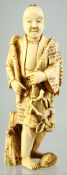 A JAPANESE CARVED IVORY OKIMONO of a man gathering fruit, 10cm high.