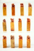 A SET OF TWELVE SMALL CHINESE SOAPSTONE BLANK SEALS, the tops carved with various animals, each
