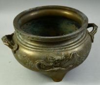 A LARGE CHINESE BRASS TWIN HANDLE TRIPOD CENSER, with relief decoration depicting a dragon, signed