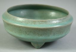 A CHINESE CELADON RU WARE BOWL, raised on three feet, 18cm diameter.