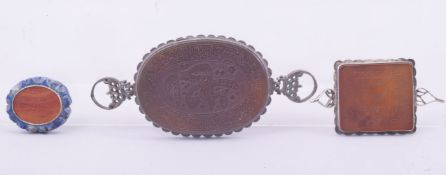 THREE ISLAMIC CARVED AGATE CALLIGRAPHIC SEALS, one inset within carved lapis, the others encased