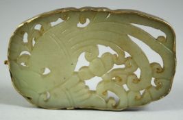 A CHINESE CARVED AND PIERCED JADE AMULET, depicting a bird, the amulet encased in a white metal