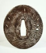 A JAPANESE SILVER INLAID AND ENGRAVED STEEL TSUBA, depicting birds in flight above crashing waves,