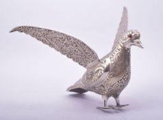 AN INDIAN ENGRAVED AND CHASED WHITE METAL MODEL OF A BIRD, with wings outstretched, 24cm long.