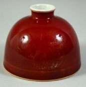 A CHINESE RED GLAZE BRUSH POT, with roundels of incised decoration under glaze, the base with six