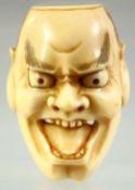 A JAPANESE CARVED IVORY NOH MASK NETSUKE, signed to the reverse, 4.5cm.