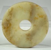 A SMALL CHINESE CARVED JADE ARCHAIC BI DISK, 8cm diameter.