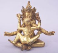 A TIBETAN EROTIC GILT BRONZE MODEL OF A COUPLE, in two pieces, 12cm high.