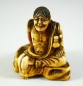 A JAPANESE CARVED IVORY NETSUKE, of a crouching male figure, 5cm high.