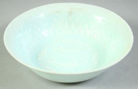 A SMALL CHINESE CELADON GLAZE BOWL, the interior with carved decoration depicting fish, 12.5cm
