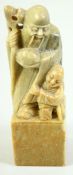 A CHINESE CARVED GREEN SOAPSTONE SEAL, carved with a figure and a boy, 12cm high.