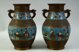 A PAIR OF ENAMELLED BRONZE TWIN HANDLE VASES, decorated with Eyptian figures and hieroglyphics, 27cm