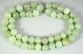 A CHINESE JADE BEAD NECKLACE, comprising 49 beads, each approx. 20mm diameter.