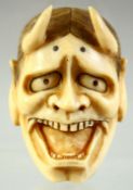 A JAPANESE CARVED IVORY NOH MASK NETSUKE, signed to the reverse, 5cm.