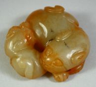 A CHINESE CARVED JADE FIGURE of a recumbent beast and young, 5cm diameter.