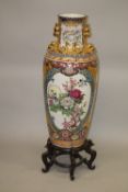 A LARGE CHINESE FLOOR STANDING PORCELAIN VASE on a hardwood stand, decorated in Japanese style