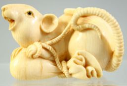 A JAPANESE CARVED IVORY OKIMONO of a rat leaning on a sack, 5.5cm long.