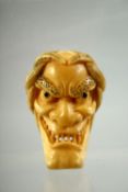 A JAPANESE CARVED IVORY NOH MASK NETSUKE, signed to the reverse, 4.5cm.