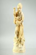 A JAPANESE CARVED IVORY OKIMONO of a sage like figure holding a cockerel standing on a rocky