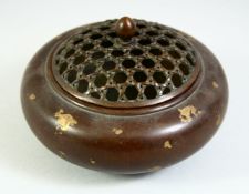 A CHINESE GOLD SPLASH BRONZE CENSER with pierced top. 4.5ins diameter.