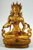 A GILT BRONZE MODEL OF A SEATED DEITY, 27cm high.